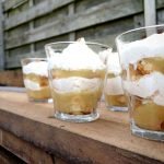 Vier glaasjes gevuld met laagjes beschuit, laagjes appelmoes en een laagje slagroom.